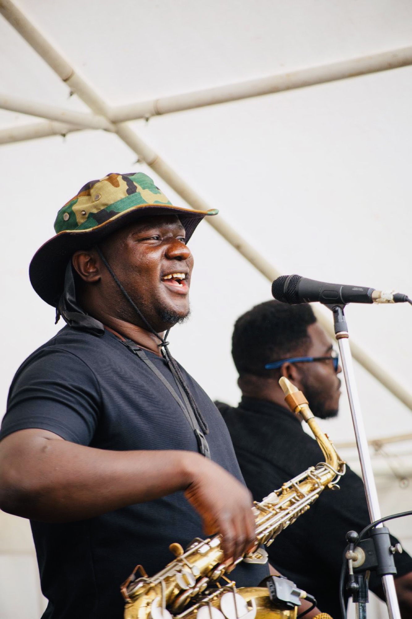 Olamide Sax performing in a grand hall.