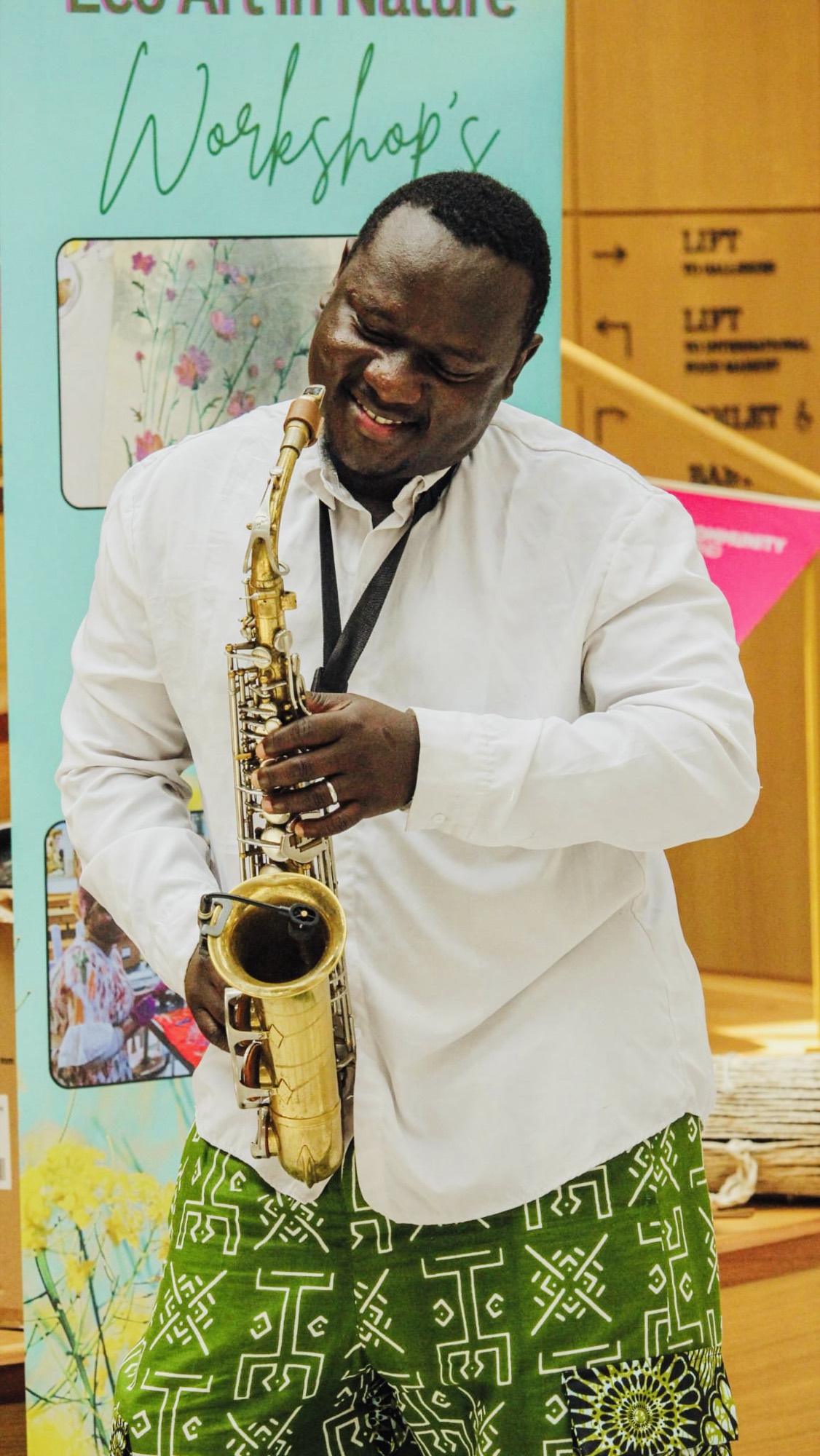 Olamide Sax facilitating a community drumming workshop — hands on the drums.